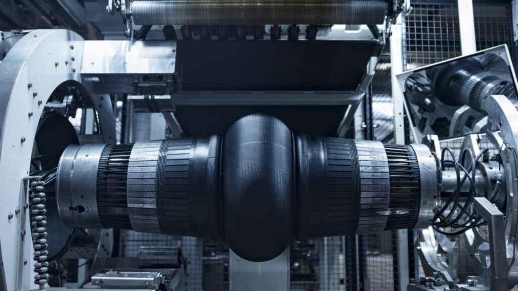 Robotic tire manufacturing machine stamping rubber tape in modern manufacture